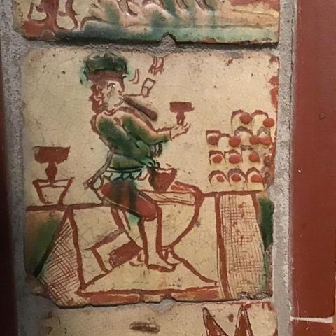 Slipware tile with a merry potter at the wheel. 18thC