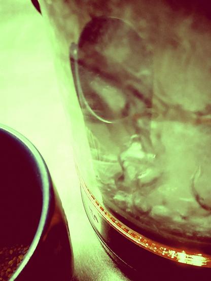 Water boiling in a kettle. Reflection of a still empty cup on the glass.