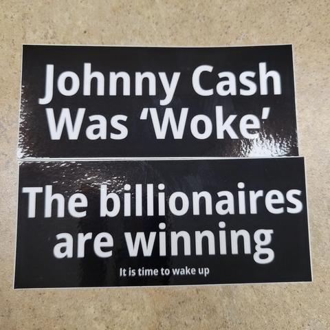 2 black amd white vinyl stickers.  Top one says Johnny Cash was "woke". The bottom one says "the billionaires are winning. It is time to wake up.