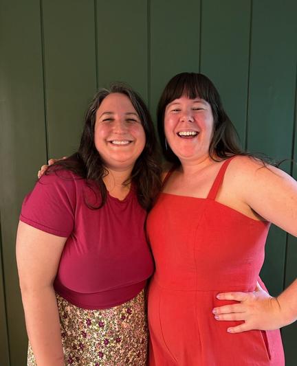 Caroline wears a berry-coloured cropped tee and a floral skirt and Helen wears a sleeveless red fitted jumpsuit.