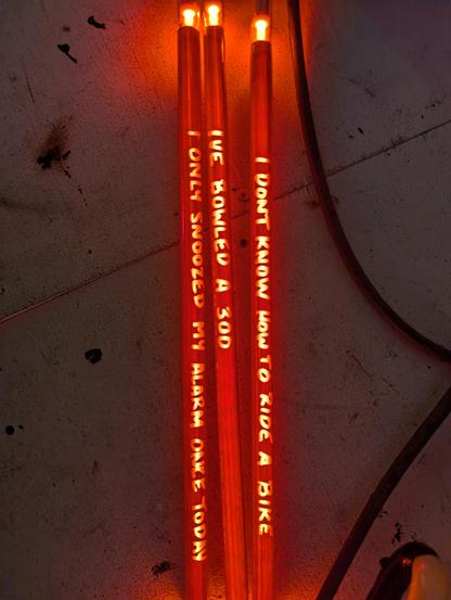 Two truths and a lie piece by Amber. The black glass powder on the outside gave the tubes an interesting brown filter with the neon fill, as well as an interesting texture. Their handwriting, Rayzisted sandblasted onto the tube, allows the bright, unfiltered neon through