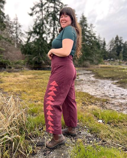 Helen wears a green tee and burgundy barrel leg pants with pink patchwork panels on the sides.