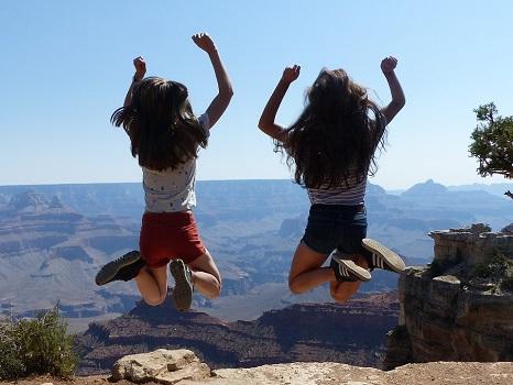 Zwei junge Mädchen von hinten, die vor dem Grand Canyon in die Luft springen
Bildrechte: Adolesco / Pixabay