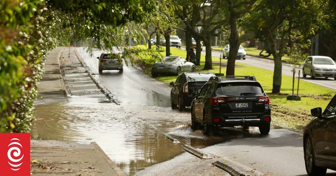 Traffic queued as cars drive through the remaining floodwater on St Lukes Road on Saturday morning.
